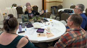 Sarah is teaching people how to play Vaesen.